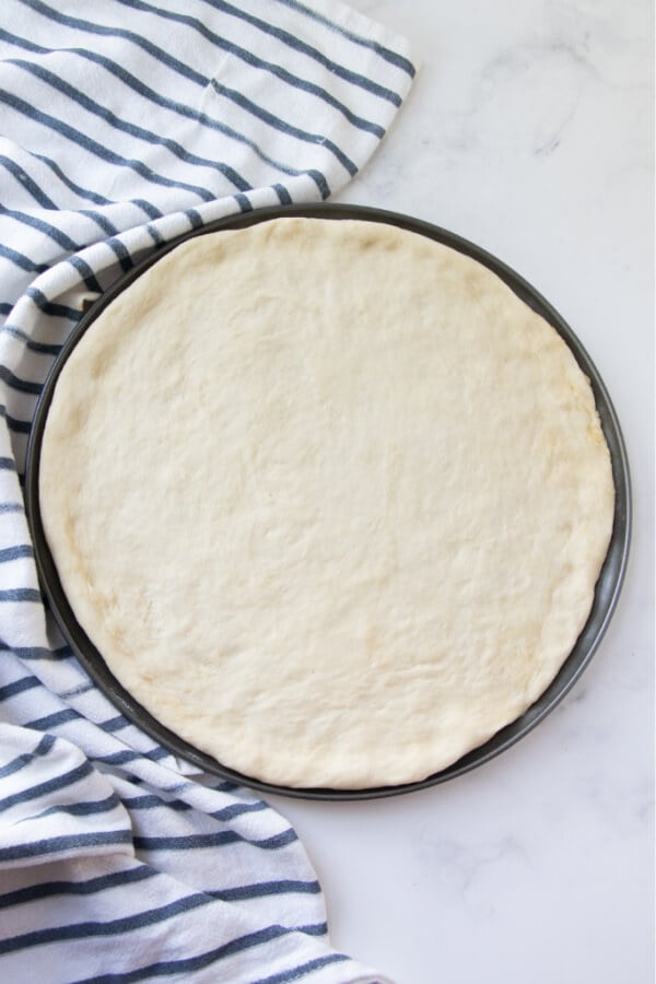 pizza dough pressed out into pan