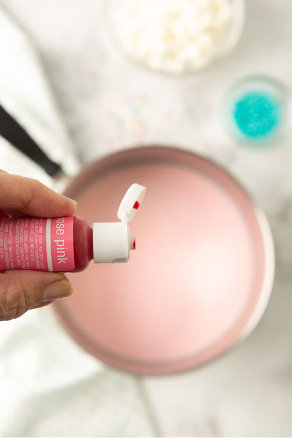 adding pink food coloring to pan