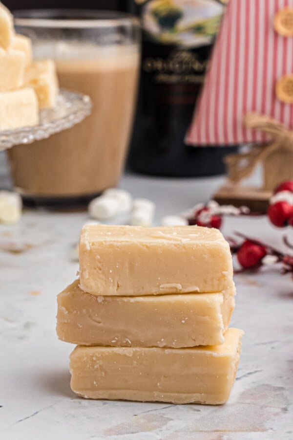 three pieces of fudge stacked with a christmas background