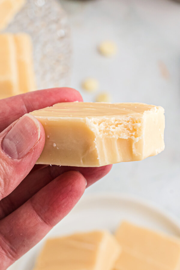 hand holding a piece of fudge with a small bite taken out of it