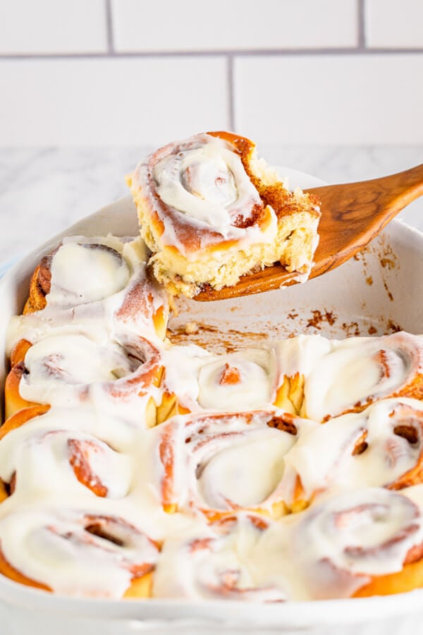 finished cinnamon roll on wooden spatula