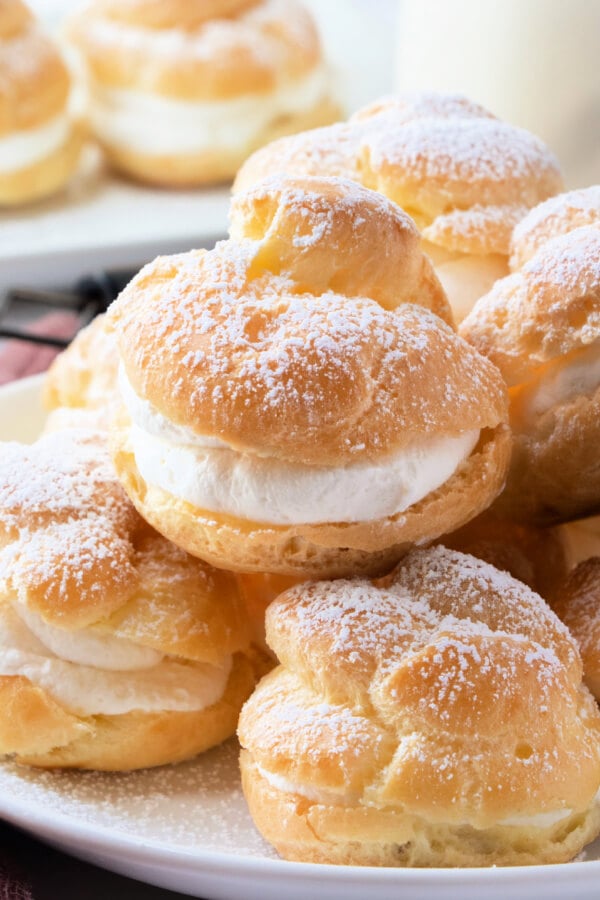 finished cream puffs stacked on plate