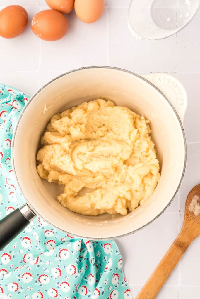 and quickly stir in flour with a wooden spoon. Continue cooking, stirring constantly until a film forms on the bottom of the pan.