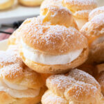classic french cream puffs stacked on plate