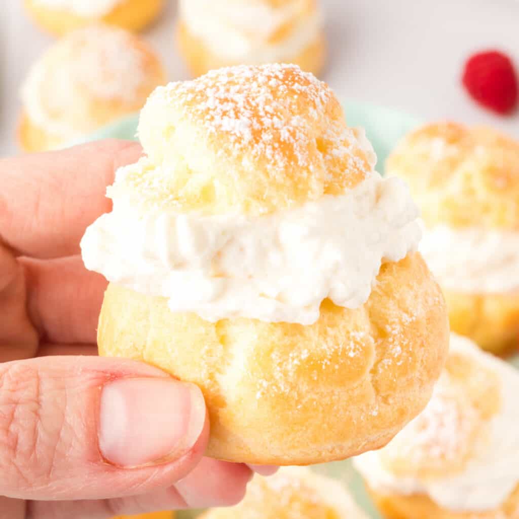 closeup of a hand holding a cream puff