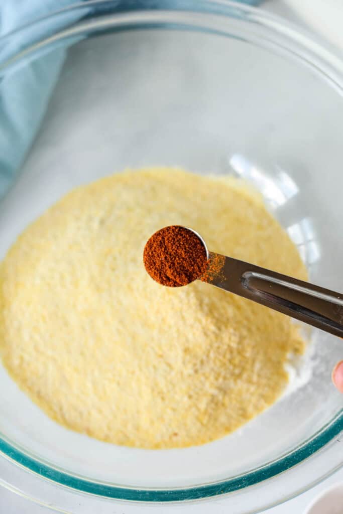 Cayenne pepper being measured into the cornmeal mixture for fried fish