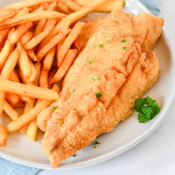 Classic fried fish recipe with crispy golden cornmeal-coated fillets and French fries
