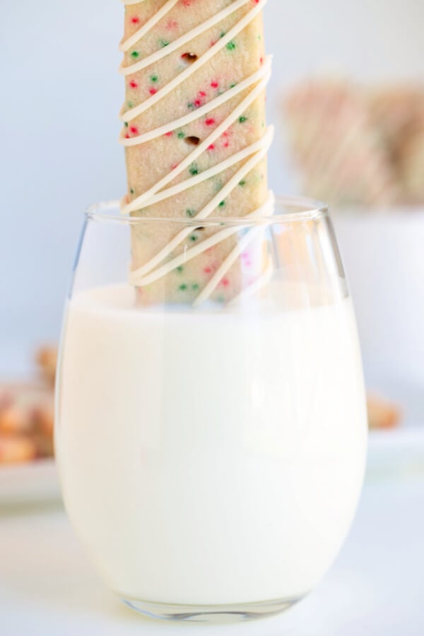 dunking a cookie in a glass of milk