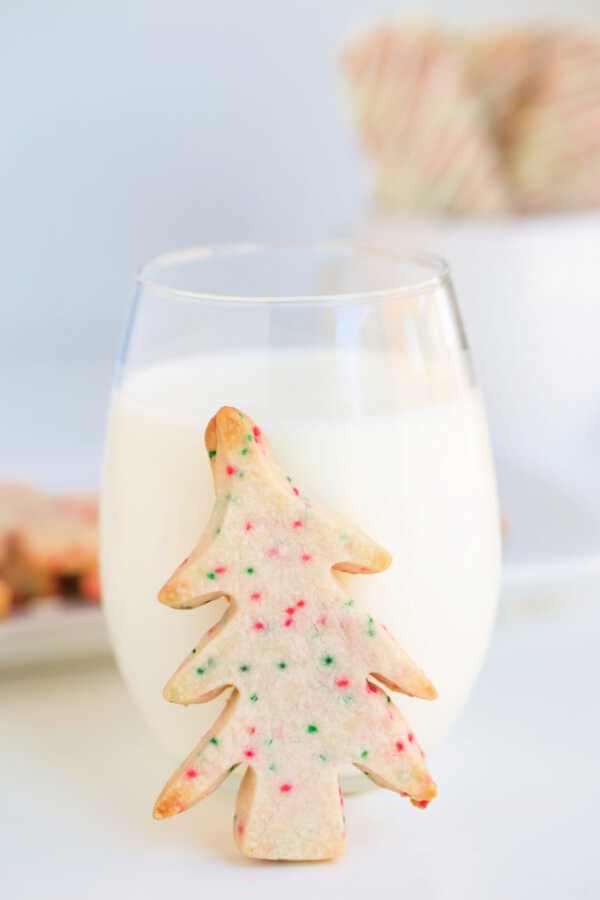 tree-shaped cookie standing in front of a glass of milk
