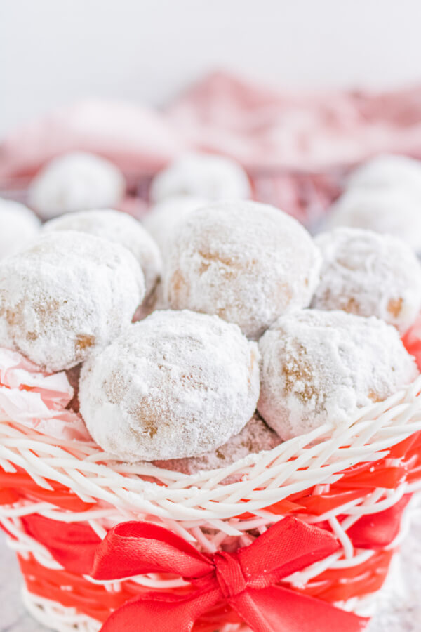 finished cookies snowball cookies stacked in a holiday basket