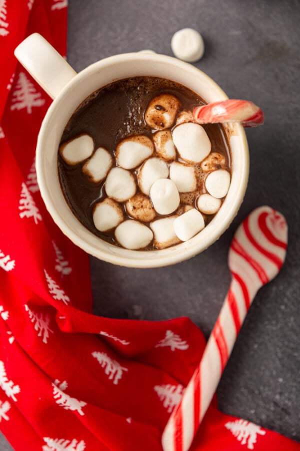 red napkin, warm mug with drink and peppermint spoon