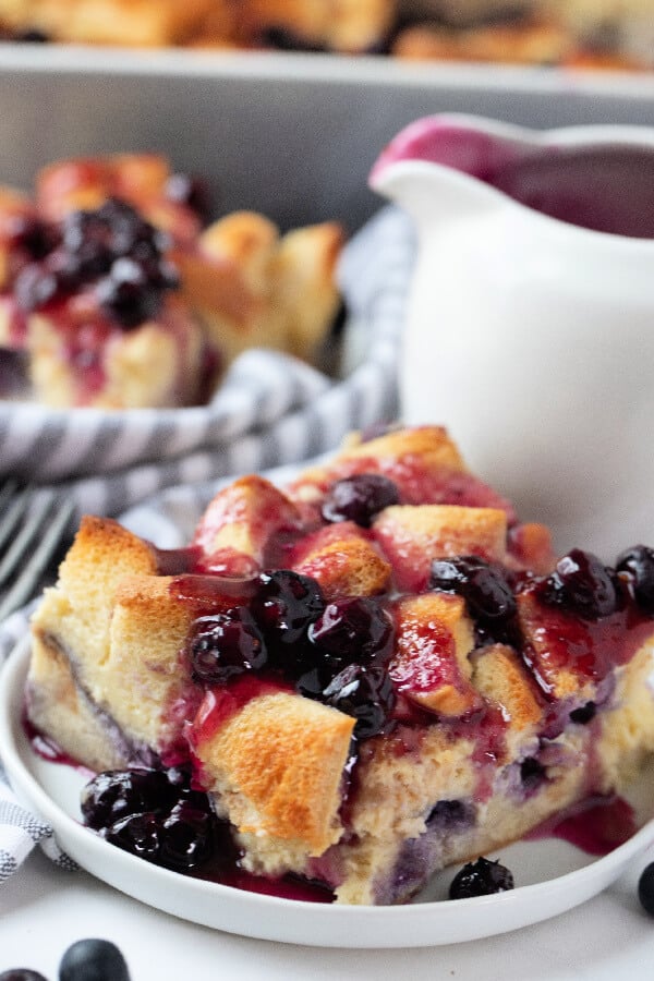 slice of overnight french toast on plate with blueberry syrup on top