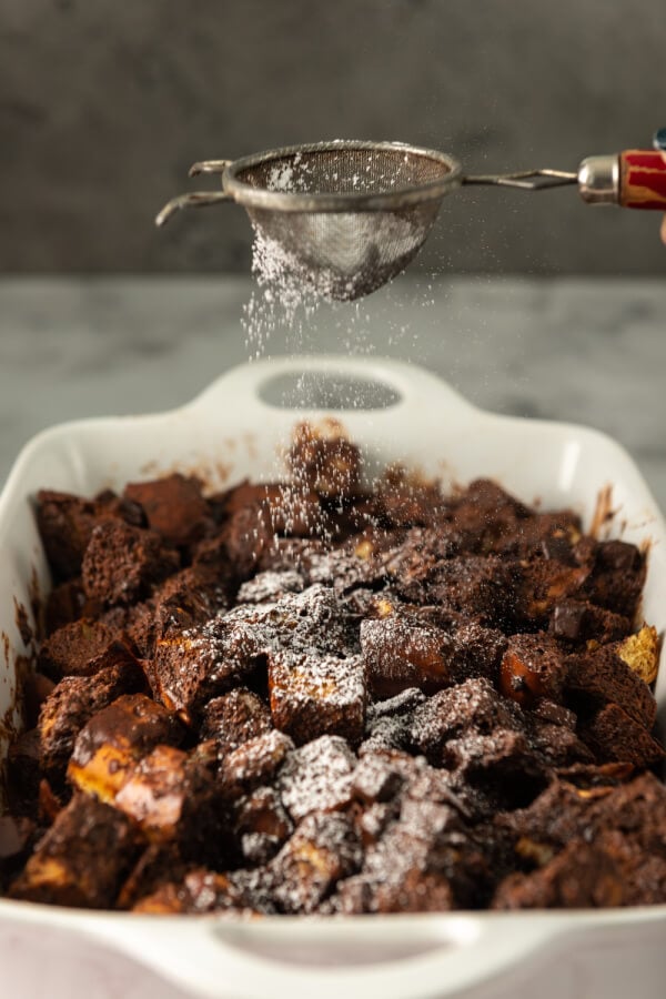 dusting powdered sugar over the top of the finished chocolate bread pudding