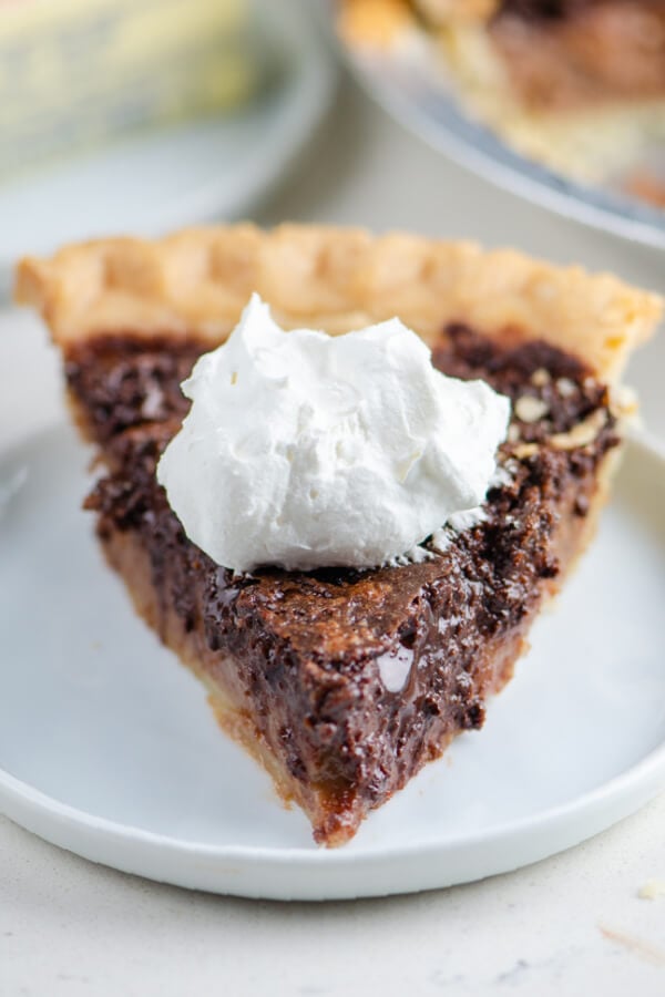 chocolate chess pie with a dollop of whipped cream on a white plate