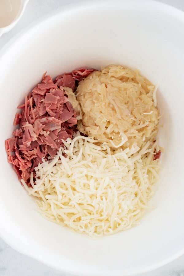 corned beef, sauerkraut, and swiss cheese in mixing bowl