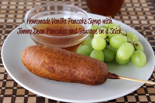 Homemade Vanilla Syrup with Jimmy Dean Pancakes & Sausage on a stick. A breakfast pancake and sausage on a plate close-up with syrup and green grapes.