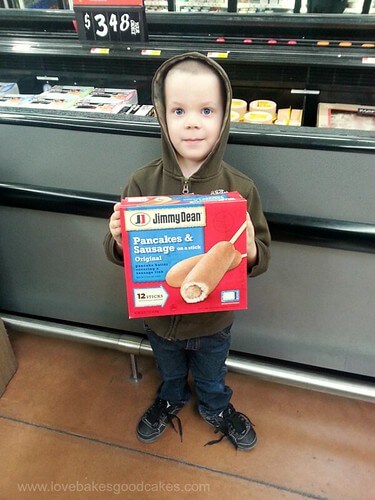Homemade Vanilla Syrup with Jimmy Dean Pancakes & Sausage on a stick. A boy holding a package of Jimmy Dean Pancake & Sausage on a stick original flavor box.