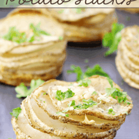 Garlic Parmesan Parslied Potato Stacks on a cutting board.