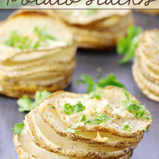 Garlic Parmesan Parslied Potato Stacks on a cutting board.