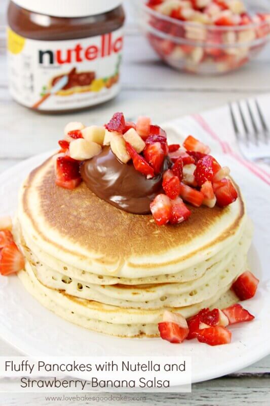 Fluffy Pancakes with Nutella and Strawberry-Banana Salsa on a white plate.