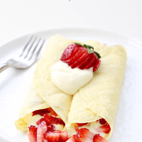 Strawberry & Lemon Cream Crepes on a white plate with a fork.