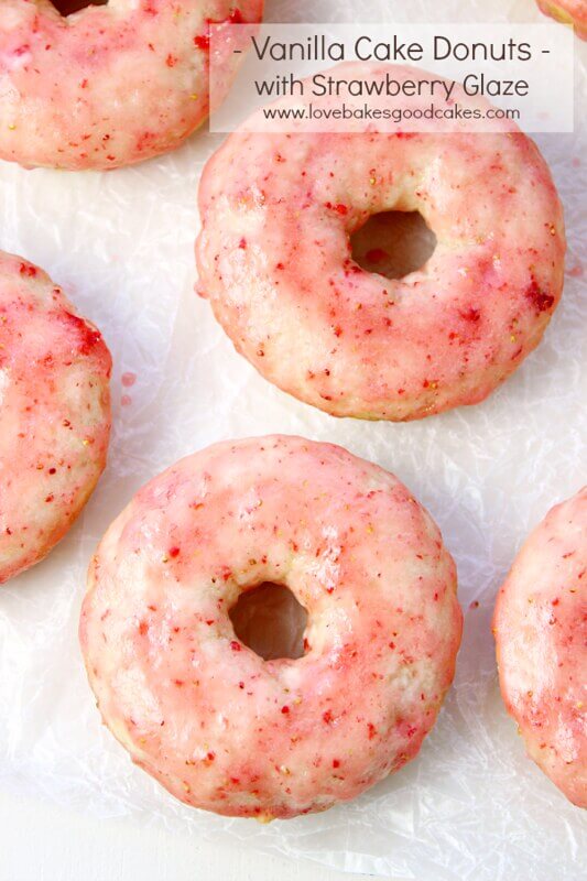 Vanilla Cake Donuts with Strawberry Glaze on wax paper.