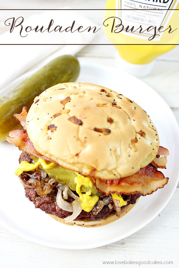 Rouladen Burger on a white plate with a pickle.