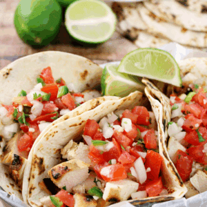 Grilled Chicken Fresco Tacos in a metal bowl lime slices.