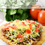 Fry Bread Taco on a white plate with fresh vegetables.