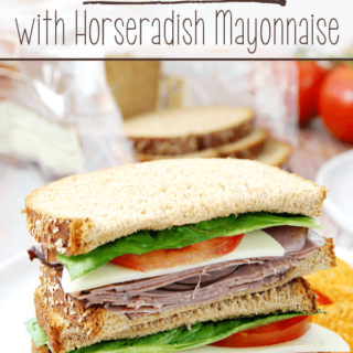 Roast Beef Sandwiches with Horseradish Mayonnaise stacked up on a white plate.