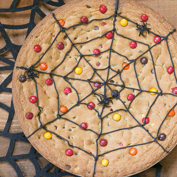 Spiderweb cookie cake laying on a cutting board.