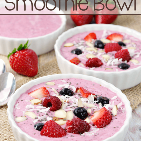 Mixed Berry Smoothies in three white bowls with fresh strawberries.