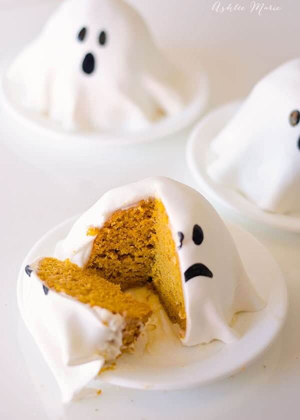 Mini pumpkin ghost cakes in white little bowls.