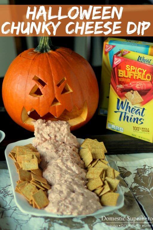 Halloween chunky cheese dip in a white bowl with crackers.