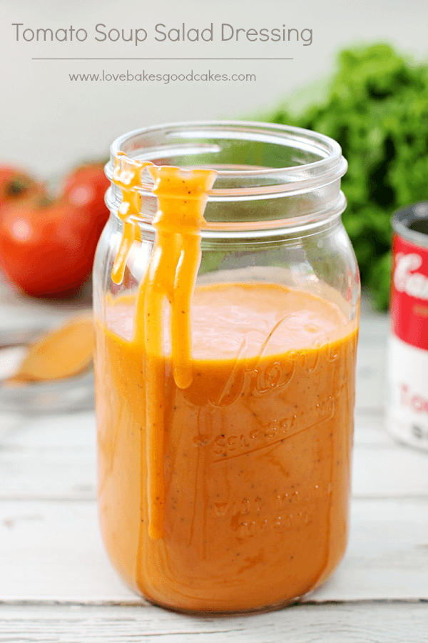 Tomato Soup Salad Dressing in a jar with the lid off and some dressing dripping down the side.