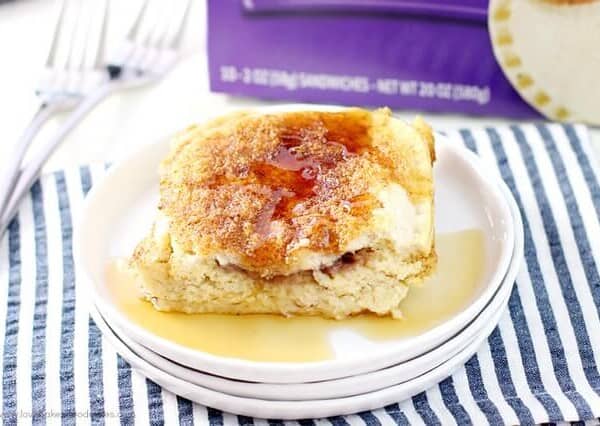Uncrustables® Overnight French Toast on a white plate with syrup.