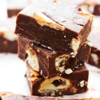 Peanut Butter Pretzel Fudge stacked up on a cutting board.