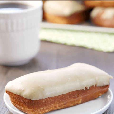 Maple Bar on a white plate with a cup of coffee.