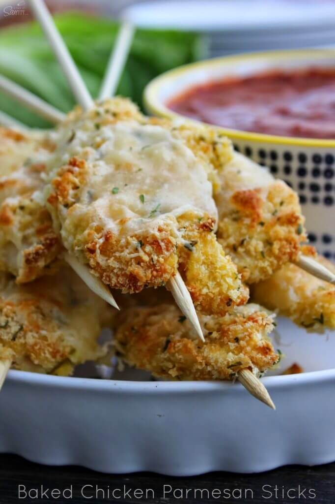 Baked Parmesan Chicken Sticks on a white plate closeup to show texture of food.