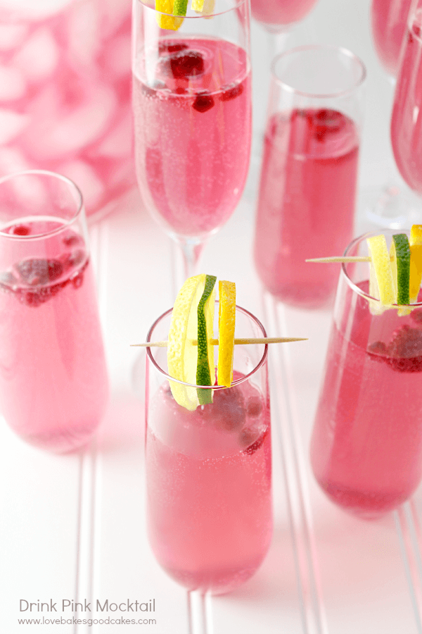 Drink Pink Mocktail in a glass with fresh strawberries and lemon lime slices.