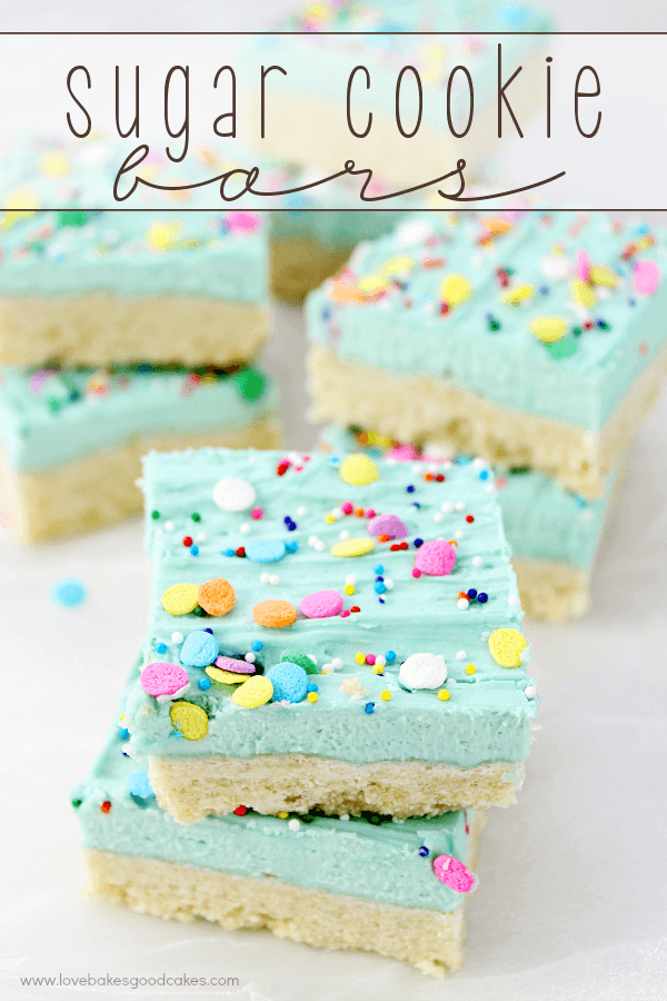 Sugar cookies stacked on parchment paper.