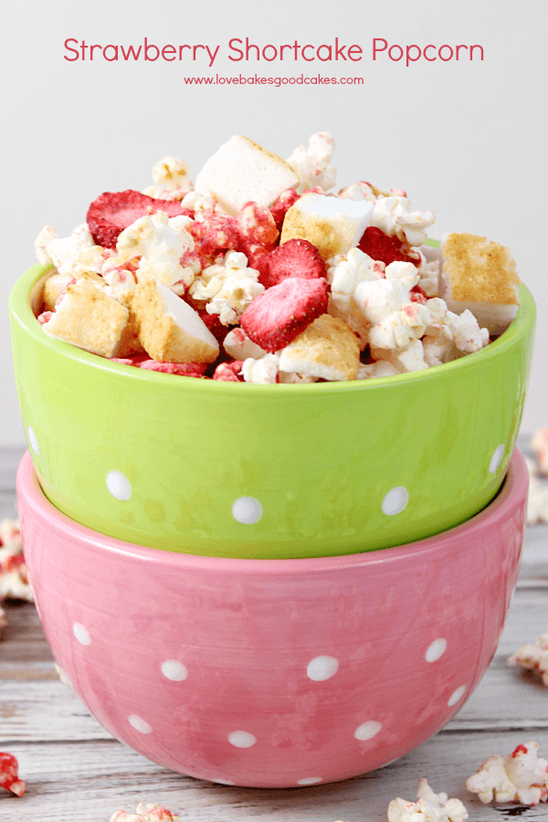 Strawberry Shortcake Popcorn in a green and pink bowls with fresh strawberries.