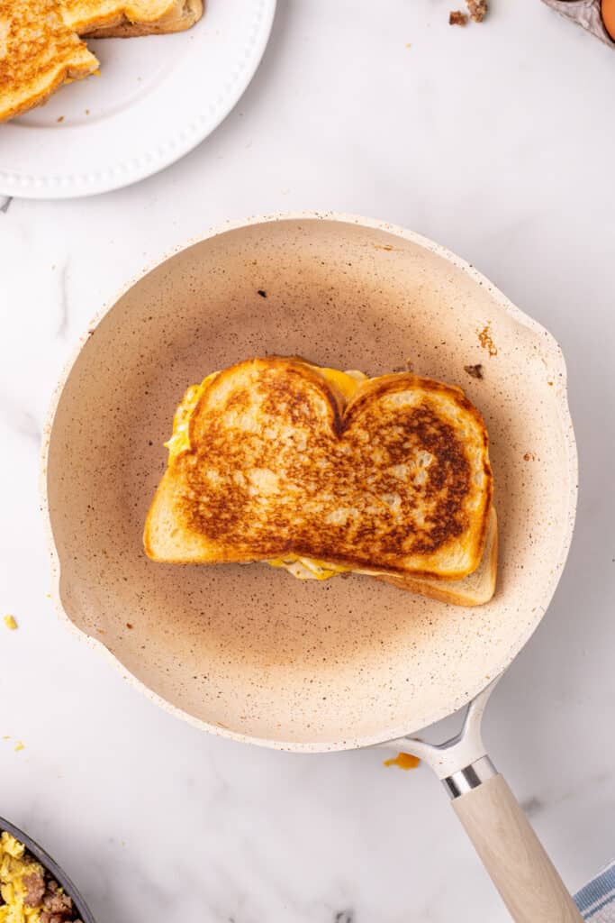 Crispy Breakfast Grilled Cheese sandwich cooking in a skillet until golden brown