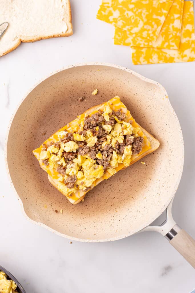 Sausage and scrambled egg filling added to a crispy breakfast grilled cheese with eggs and sausage