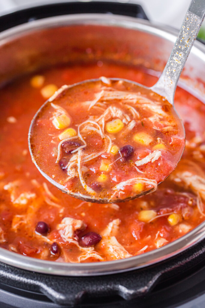 Ladling soup out of a pressure cooker.