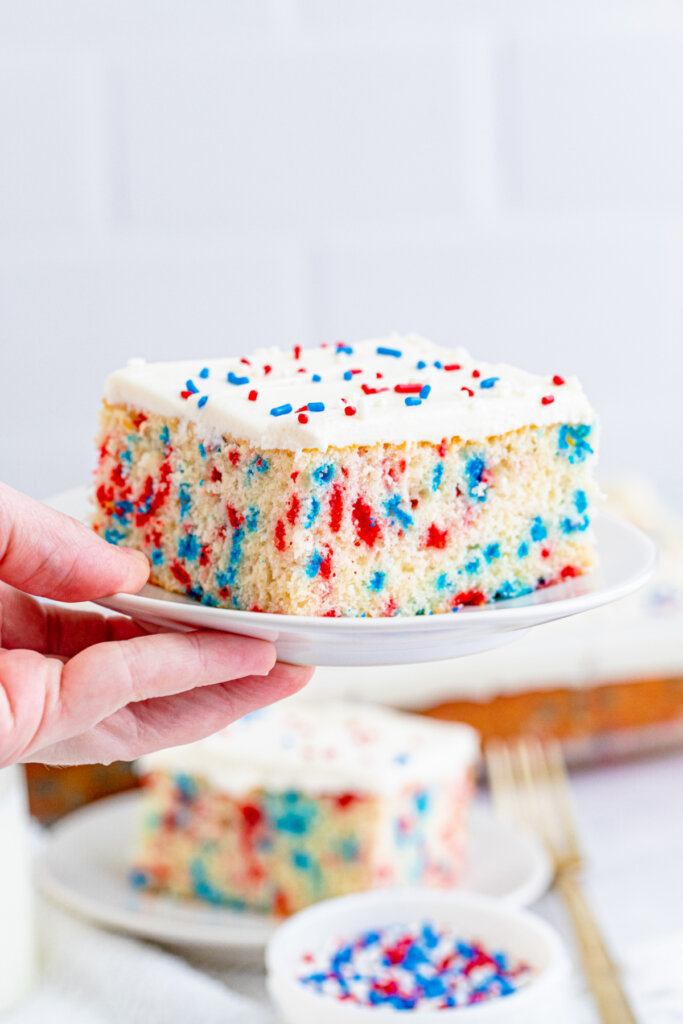 hand holding slice of dessert on plate