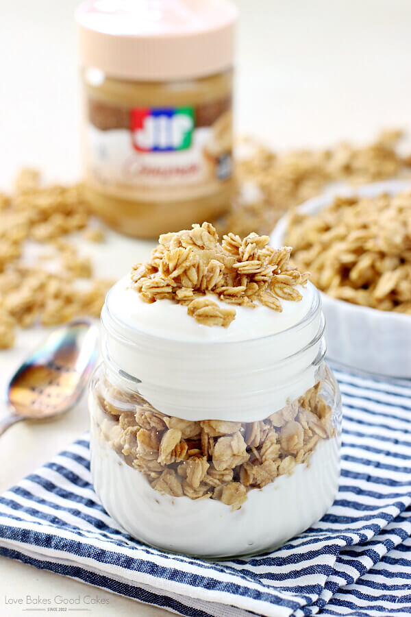 Peanut Butter Granola in a glass jar and a white bowl.