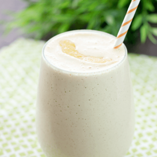 Peach & Oatmeal Smoothie in a glass with a straw.