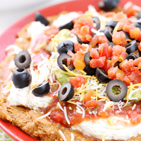 7 Layer Bean Dip on a red plate.