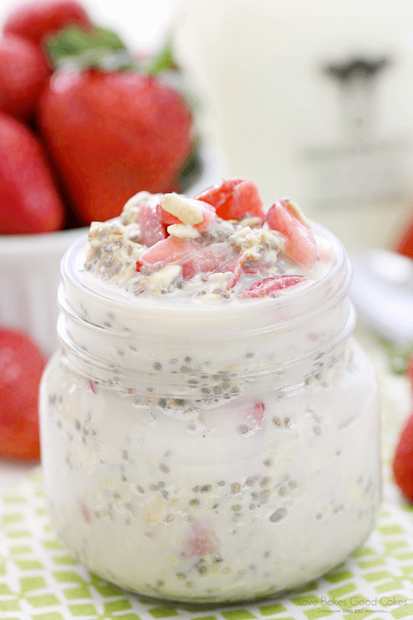 Strawberry Vanilla Overnight Oatmeal in a jar with fresh strawberries.